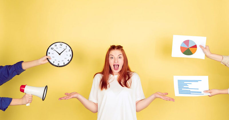 Picdrop-Academy-Blogbeitrag-Silke-Gueldner Eine Person mit rotbraunen Haaren steht in der Mitte und hält die Hände offen. Links wird eine Uhr mit Ziffernblatt gezeigt, rechts werden zwei Blätter mit Diagrammen gehalten, eines mit einem Tortendiagramm und das andere mit Text.